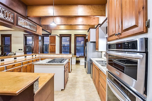 kitchen with pendant lighting, sink, a center island, kitchen peninsula, and stainless steel double oven