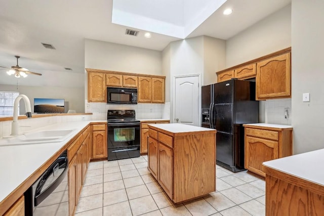 kitchen with light tile patterned flooring, sink, a kitchen island, and black appliances