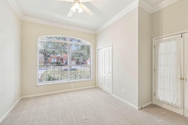 spare room featuring ornamental molding, light colored carpet, and a healthy amount of sunlight