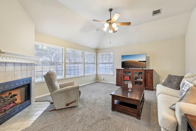 carpeted living room with vaulted ceiling, ceiling fan, and a fireplace