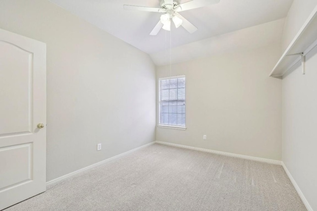 empty room with lofted ceiling, light colored carpet, and ceiling fan