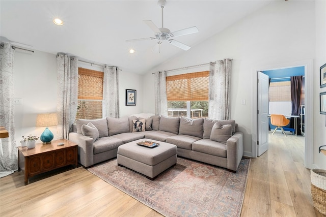 living room featuring ceiling fan, high vaulted ceiling, and light wood-type flooring