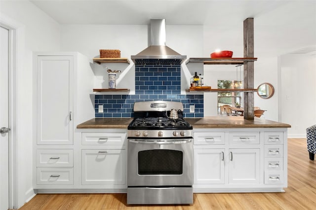 kitchen featuring white cabinets, range hood, light hardwood / wood-style floors, and stainless steel gas range