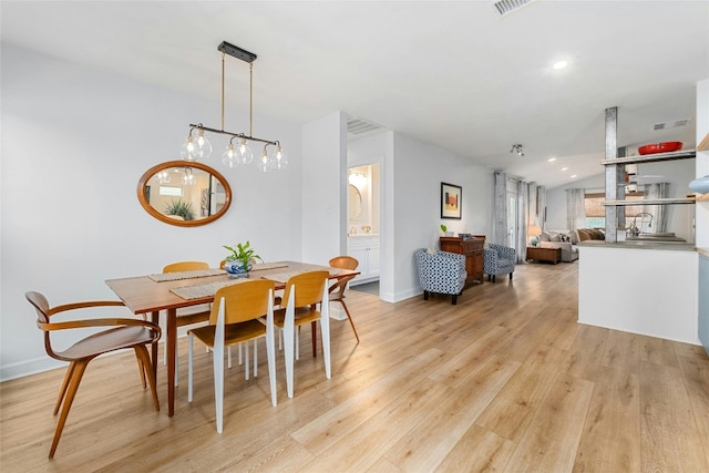 dining area with lofted ceiling and light wood-type flooring