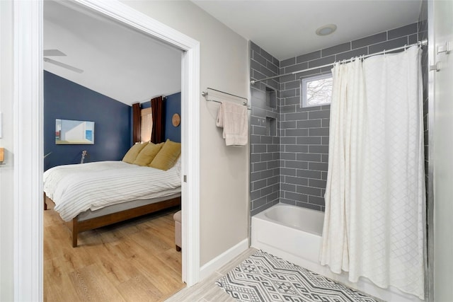 bathroom featuring shower / bath combination with curtain, ceiling fan, lofted ceiling, and hardwood / wood-style floors