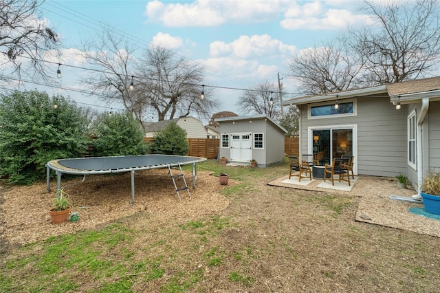 view of yard featuring a storage unit, a patio area, and a trampoline