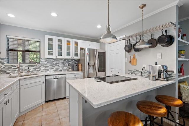 kitchen with stainless steel appliances, sink, white cabinets, and a kitchen breakfast bar