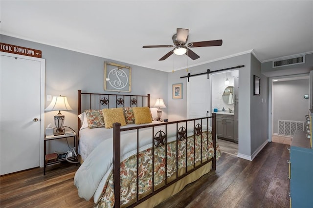 bedroom with dark hardwood / wood-style floors, a barn door, sink, and crown molding