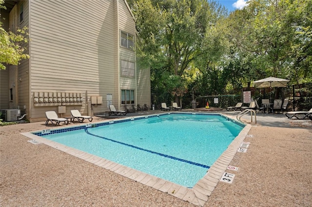 view of pool featuring a patio and central air condition unit