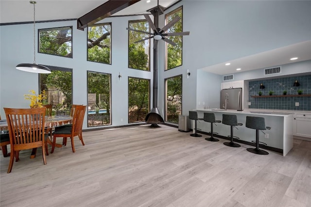 sunroom / solarium featuring beamed ceiling and ceiling fan