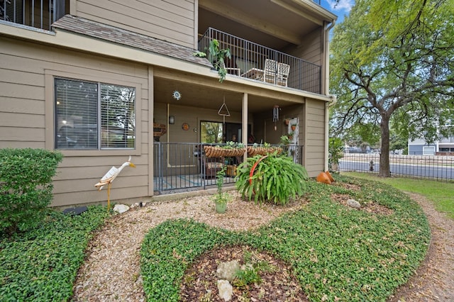 view of exterior entry with a patio and a balcony