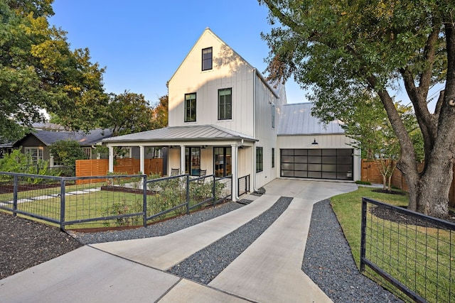 modern farmhouse featuring a porch, a garage, and a front yard