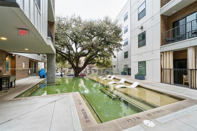 view of pool with a water view and a patio area