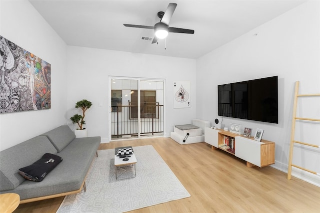 living room with ceiling fan and light hardwood / wood-style flooring