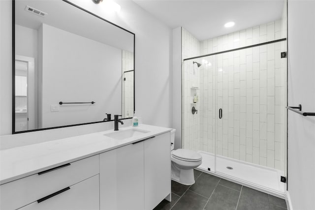 bathroom featuring vanity, tile patterned floors, toilet, and walk in shower