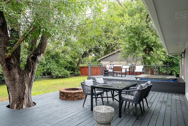 wooden deck featuring a yard, a fire pit, and a jacuzzi