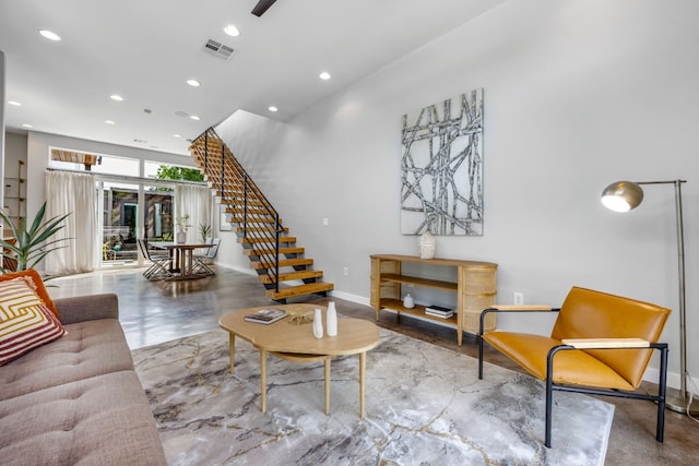 living room featuring baseboards, visible vents, stairway, concrete flooring, and recessed lighting