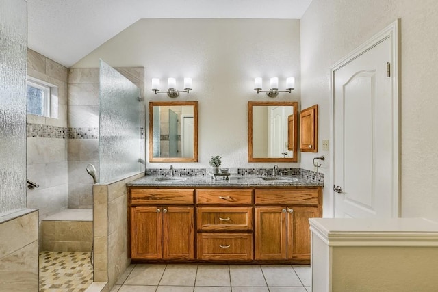 bathroom featuring tiled shower, tile patterned floors, vanity, and lofted ceiling