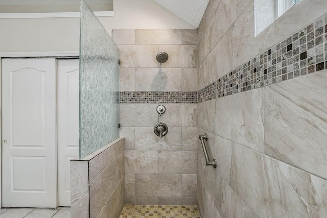 1212 Dove Cir, Cedar Park, TX 78613 - bathroom with tiled shower, tile patterned flooring, and lofted ceiling
