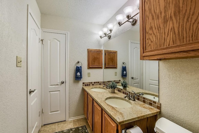 bathroom featuring vanity, toilet, and a textured ceiling