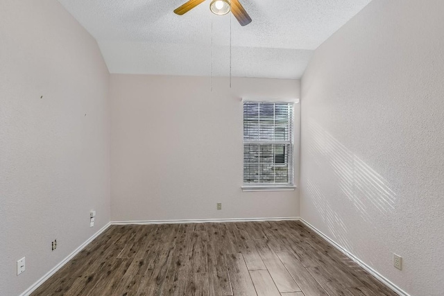 unfurnished room with ceiling fan, lofted ceiling, a textured ceiling, and dark hardwood / wood-style flooring