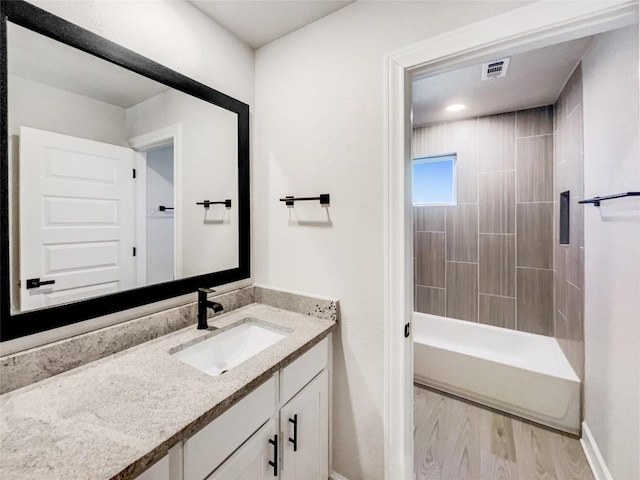 17401 Howdy Way, Manor, TX 78653 - full bathroom featuring vanity, baseboards, wood finished floors, and shower / tub combination