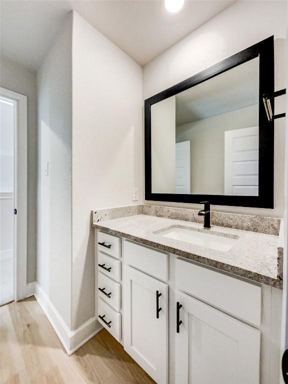 17401 Howdy Way, Manor, TX 78653 - bathroom featuring vanity, wood finished floors, and baseboards