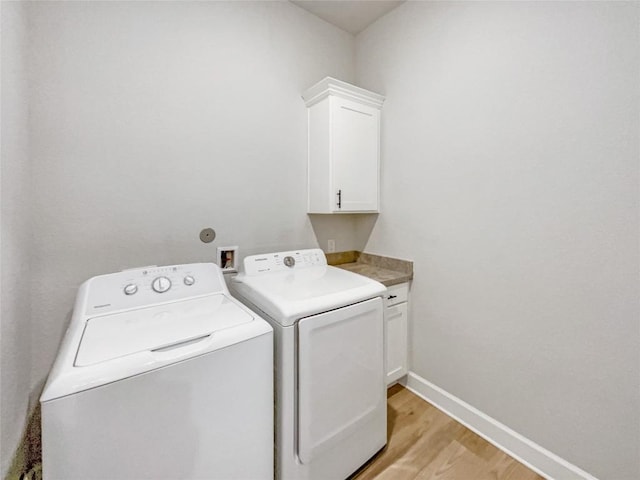 17401 Howdy Way, Manor, TX 78653 - washroom with cabinet space, washer and clothes dryer, light wood finished floors, and baseboards