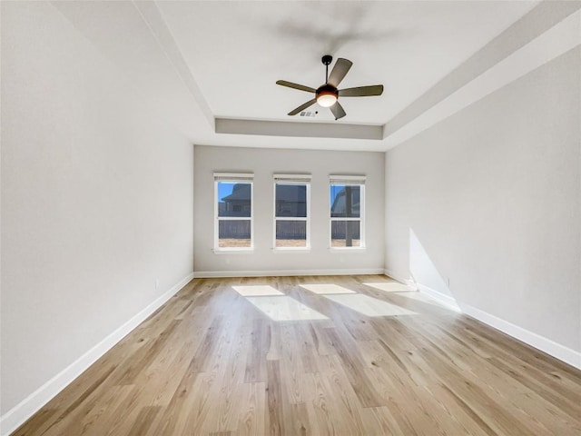 17401 Howdy Way, Manor, TX 78653 - spare room with a raised ceiling, baseboards, a ceiling fan, and wood finished floors