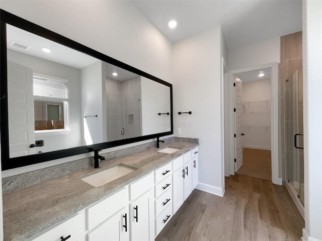 17401 Howdy Way, Manor, TX 78653 - full bath with double vanity, a stall shower, a walk in closet, wood finished floors, and recessed lighting