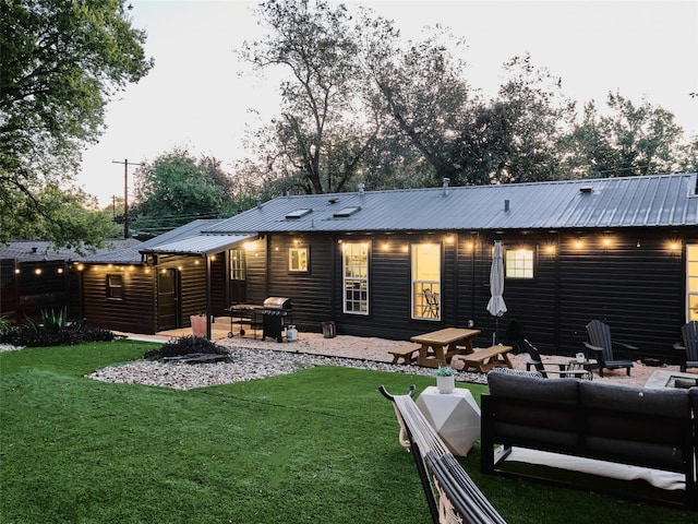 back house at dusk with a yard and an outdoor hangout area