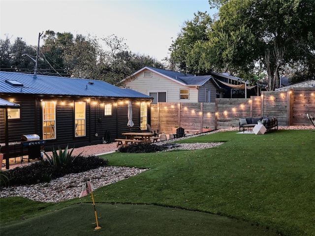 back house at dusk featuring a yard