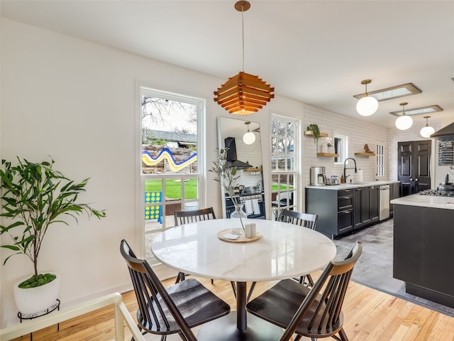 dining space with sink and light hardwood / wood-style flooring