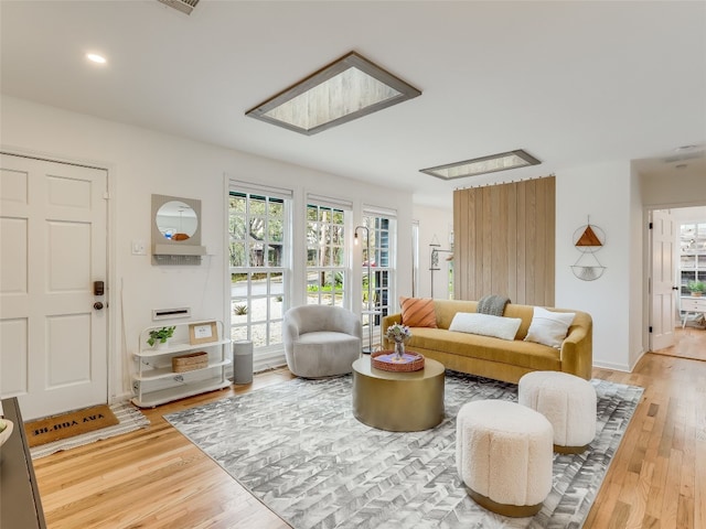 living room featuring hardwood / wood-style flooring and a skylight