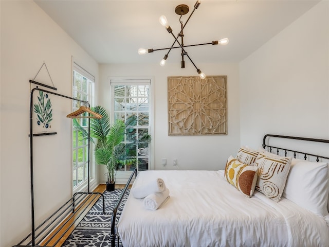 bedroom with hardwood / wood-style floors and a notable chandelier