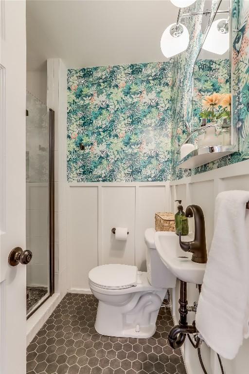 bathroom featuring toilet and a shower with shower door