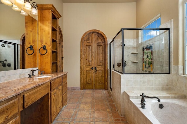 bathroom with vanity and shower with separate bathtub