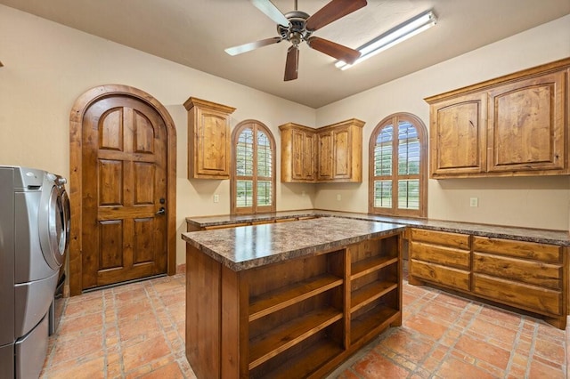 kitchen with separate washer and dryer, a center island, and ceiling fan