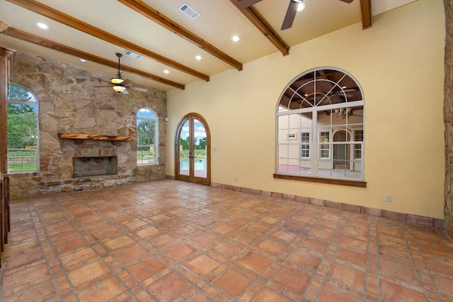 unfurnished living room with beamed ceiling, ceiling fan, a fireplace, and high vaulted ceiling