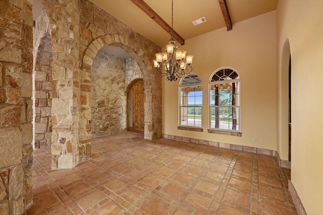 unfurnished room with an inviting chandelier, beam ceiling, and high vaulted ceiling