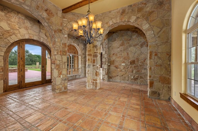 interior space with an inviting chandelier and beam ceiling