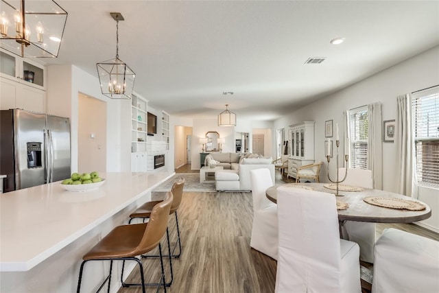 dining room featuring a notable chandelier, hardwood / wood-style floors, and built in features