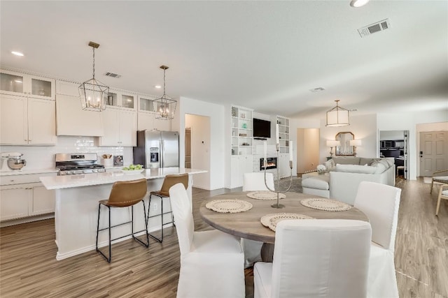 dining room featuring a fireplace and light hardwood / wood-style flooring