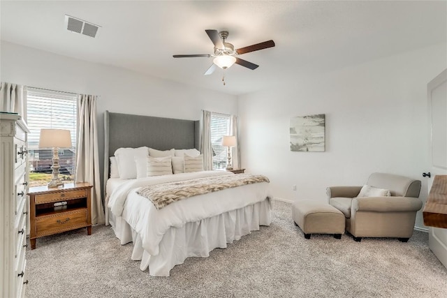 bedroom with multiple windows, light colored carpet, and ceiling fan