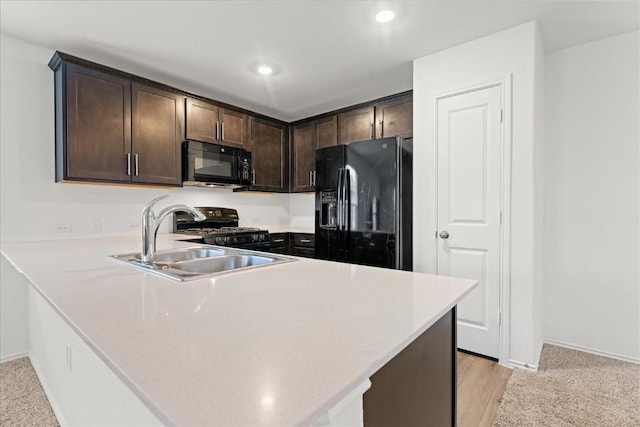 kitchen featuring sink, dark brown cabinets, black appliances, and kitchen peninsula