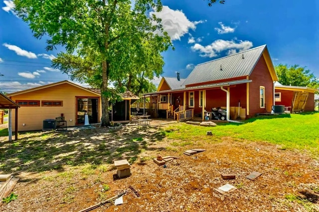 1307 Wright St, Llano, TX 78643 - back of property with cooling unit, metal roof, and a lawn