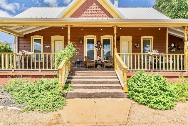 1307 Wright St, Llano, TX 78643 - view of front of home with a porch, metal roof, and a chimney