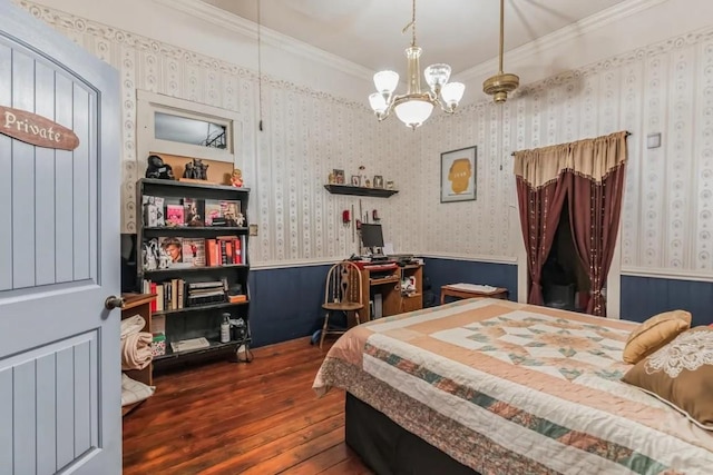 bedroom with dark hardwood / wood-style flooring, ornamental molding, and an inviting chandelier