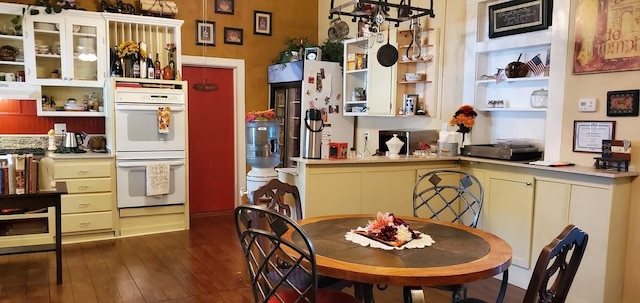 kitchen with refrigerator, dark hardwood / wood-style floors, and white double oven