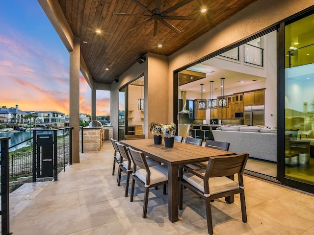 dining space with wood ceiling, ceiling fan, and a water view